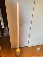 Tall vertical LED floor lamp on cylindrical base