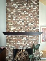 Front view of dark stained wood mantel shelf installed on brick fireplace