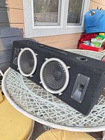 Front angled view showing two subwoofers, tweeters, port holes and handle