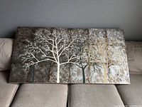 Front view of rectangular canvas painting showing tree silhouettes and textured background