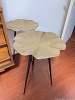 Two gold metal side tables with black legs