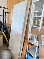 Stack of white interior doors leaning against wall showing overall size and panel style