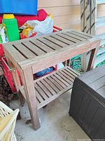 Full view of wooden two-tier table next to other items