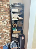 Full view of tall narrow dark brown bookcase with shelving