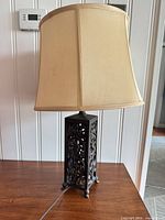 Full view of lamp showing shade, ornate bronze base and power cord