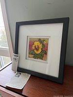 Full view of framed batik artwork on stand