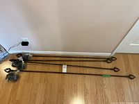 Four metal curtain rods with hardware bags on floor