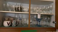 cabinet shelves with assorted glassware and mugs