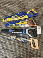 Four hand saws stacked showing brands and handles