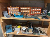 Overall view of shelving with organizers, press, clamp, drill bits and hand tools