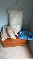 All three items: packaged white down duvet, folded beige blanket, folded blue blanket