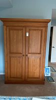 Front view of solid pine wardrobe showing double doors with recessed panels and crown molding