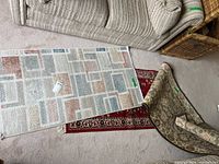 Three runners on carpeted floor, geometric runner on top, red runner beneath, green-beige runner folded