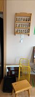 Group showing spice rack on wall, yellow wire shelf, bed tray, wicker tray, wood step stool
