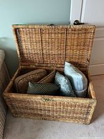open wicker trunk showing interior and pillows