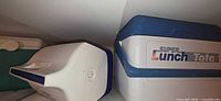 White and blue Super Lunch Tote cooler alongside white-capped Igloo Playmate