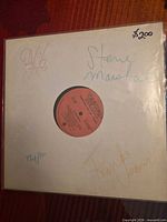 Front of white sleeve showing all four signatures and price notation