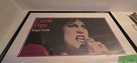 Framed poster showing Carole Pope singing, mat and frame visible