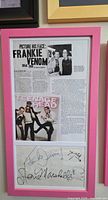 Overall view of pink frame containing article, photo, autograph sheet