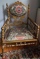Full front view of gilded bobbin armchair showing upholstery and frame