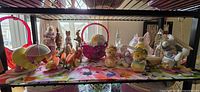 Wide view of shelf with glass, ceramic, and plush Easter decorations