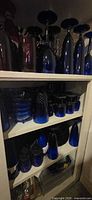 shelved cobalt blue stemware, tumblers, bowls, pitcher