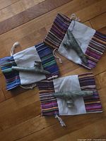Three soapstone pipes placed on individual striped drawstring pouches