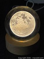 Crystal sphere illuminated on wood base