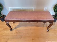 Full front view of bench showing wood frame, legs, upholstery condition