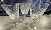 Three cut crystal wine glasses standing side by side