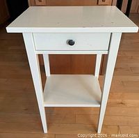 Front view showing drawer, knob, and shelf