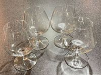 All four clear glass brandy snifters on countertop