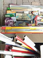 Overview of boxed model kits, metal rails, tools and vinyl film rolls in and around boxes