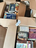 Overview of open boxes with assorted books showing spines and covers