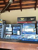 Tote and shelf with multiple empty aircraft model boxes including Corgi, Franklin Mint, HM