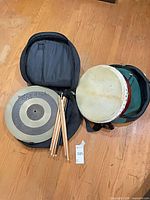 Overall lot: frame drum, cymbal, drumsticks, bag