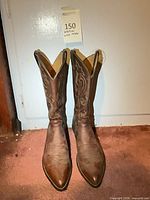Front view of brown leather Justin cowboy boots standing upright