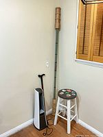 Corner view showing tower heater-fan, walking cane, earthquake door brace, wooden stool