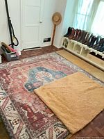 Large Persian style rug covering floor, small beige shag rug on top