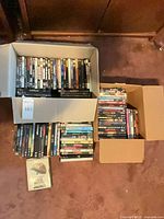 Three boxes containing assorted DVD cases