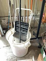 Lot view showing step stool inside bucket with broom and other tools nearby