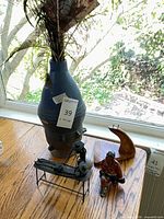 Group shot showing pottery vase with feathers, metal sculpture, wood sail form, ceramic figurine