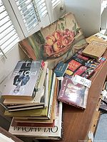 Stacked books, fruit artwork, Canasta card boxes on shelf