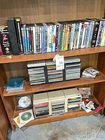 Shelving with rows of DVD and CD cases and plastic rack