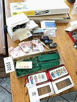 Mixed lot on table showing model kit box, die-cast cars, sprues, figure sets and accessory packs
