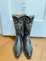 Front view of Sears black leather cowboy boots showing stitched eagle design and pointed toes