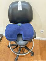 Front view of Soundseat drafting stool with blue cushion placed on seat