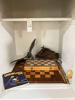 Group view showing chess board, storage case, metal bird sculpture and book