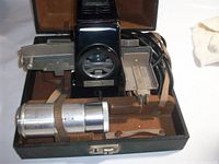 Projector, lens barrel, slide carriers and power cord secured inside open case