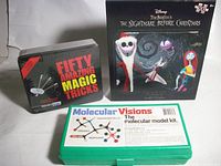 Front view of all three boxed items: magic tricks tin, Nightmare Before Christmas puzzle, Molecular Visions kit